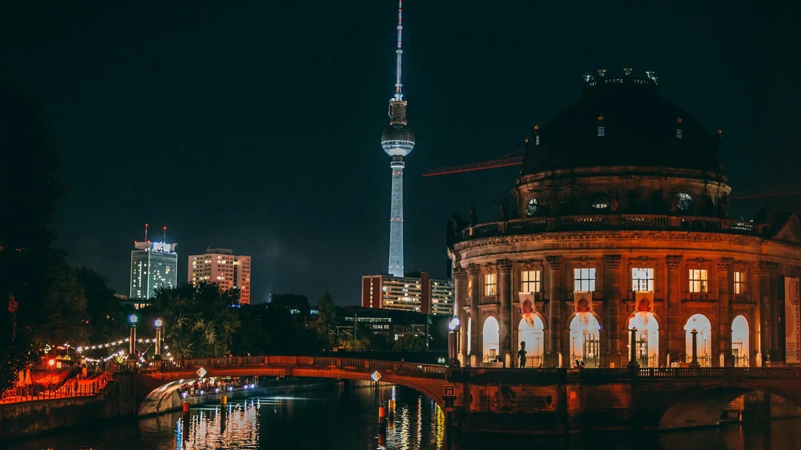 Vista nocturna del río Spree en Berlín con la torre de televisión iluminada y el Museo Bode al fondo