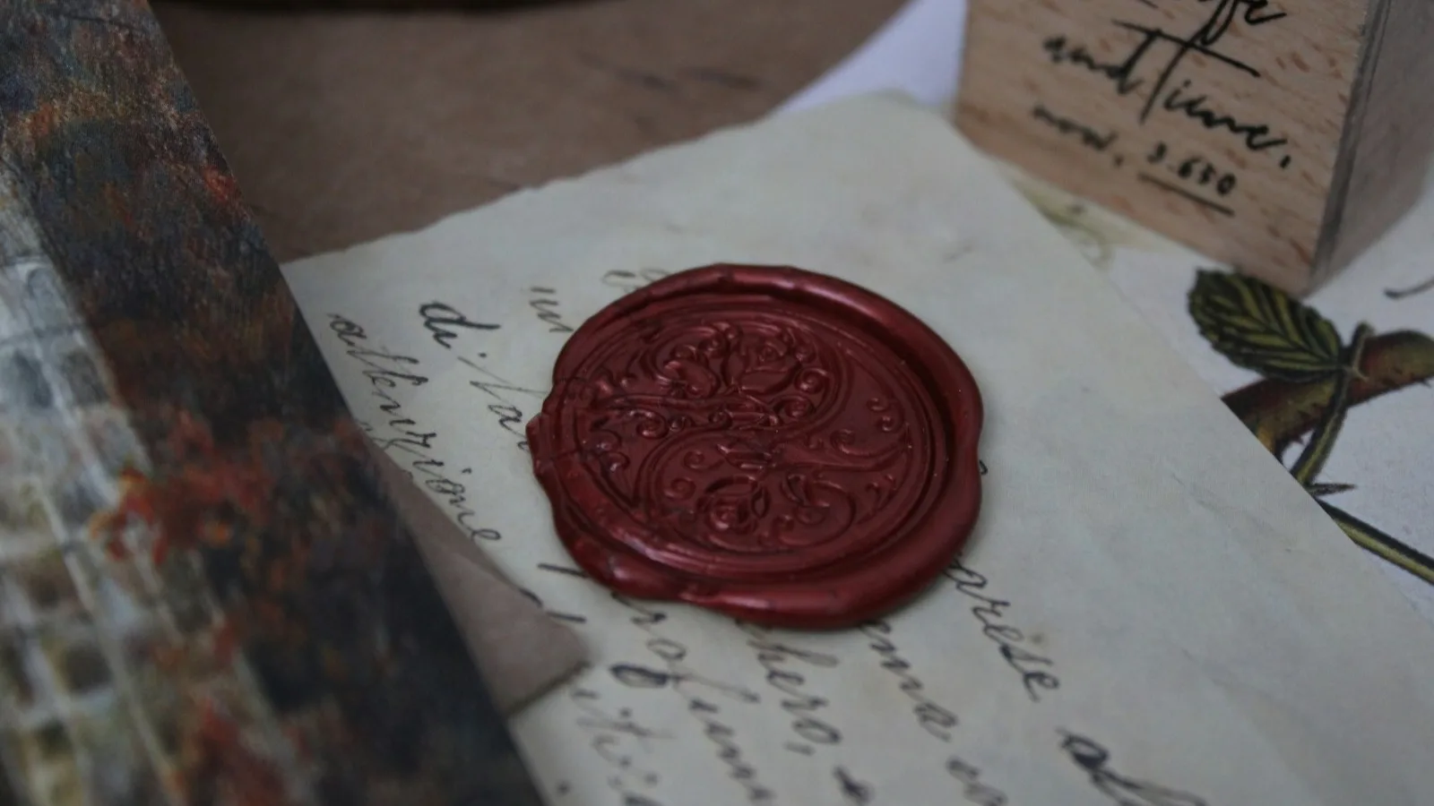 Sello de lacre rojo estampado sobre una carta manuscrita antigua, en penumbra