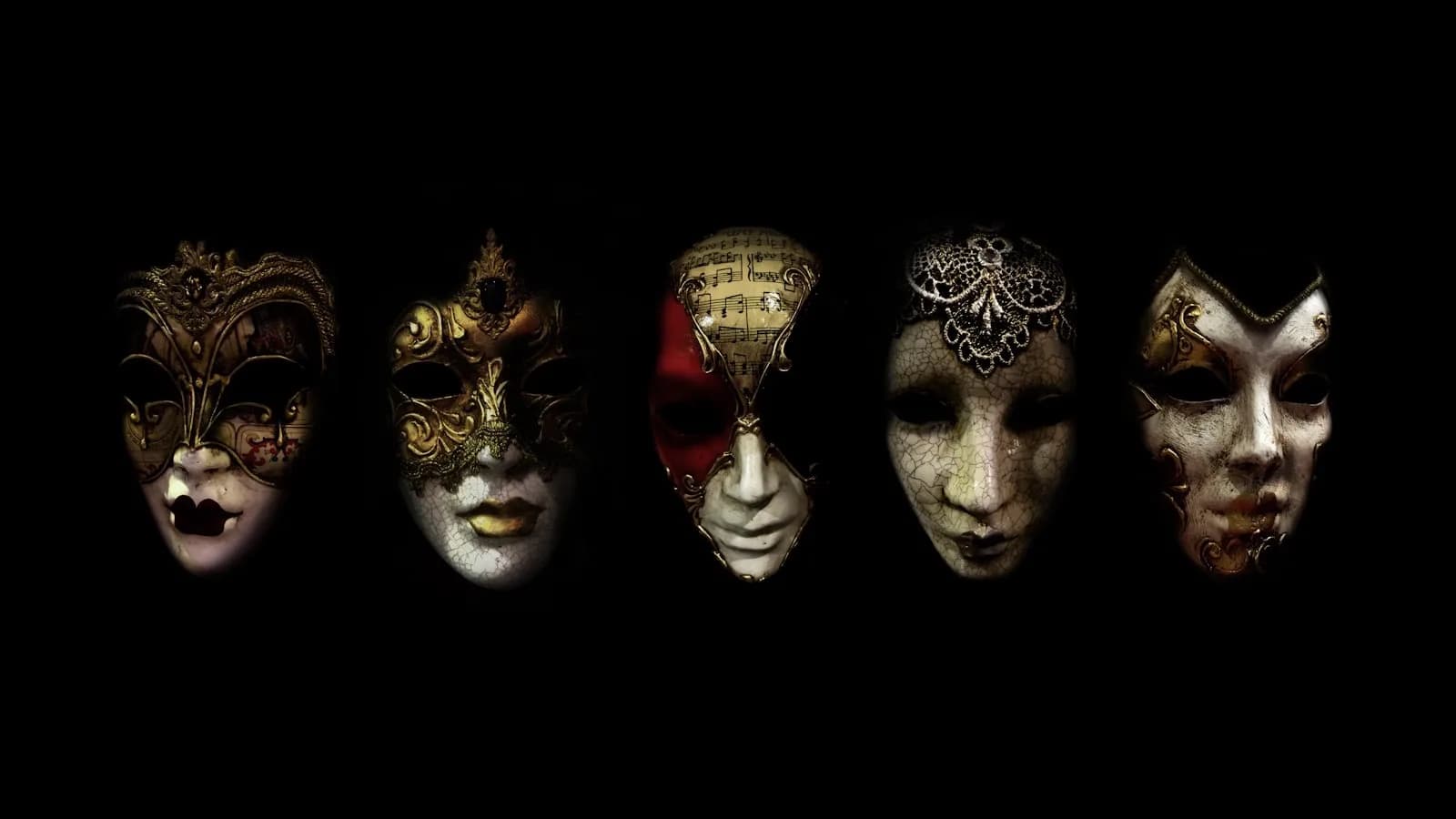 Cinco máscaras venecianas ornamentadas alineadas contra un fondo negro