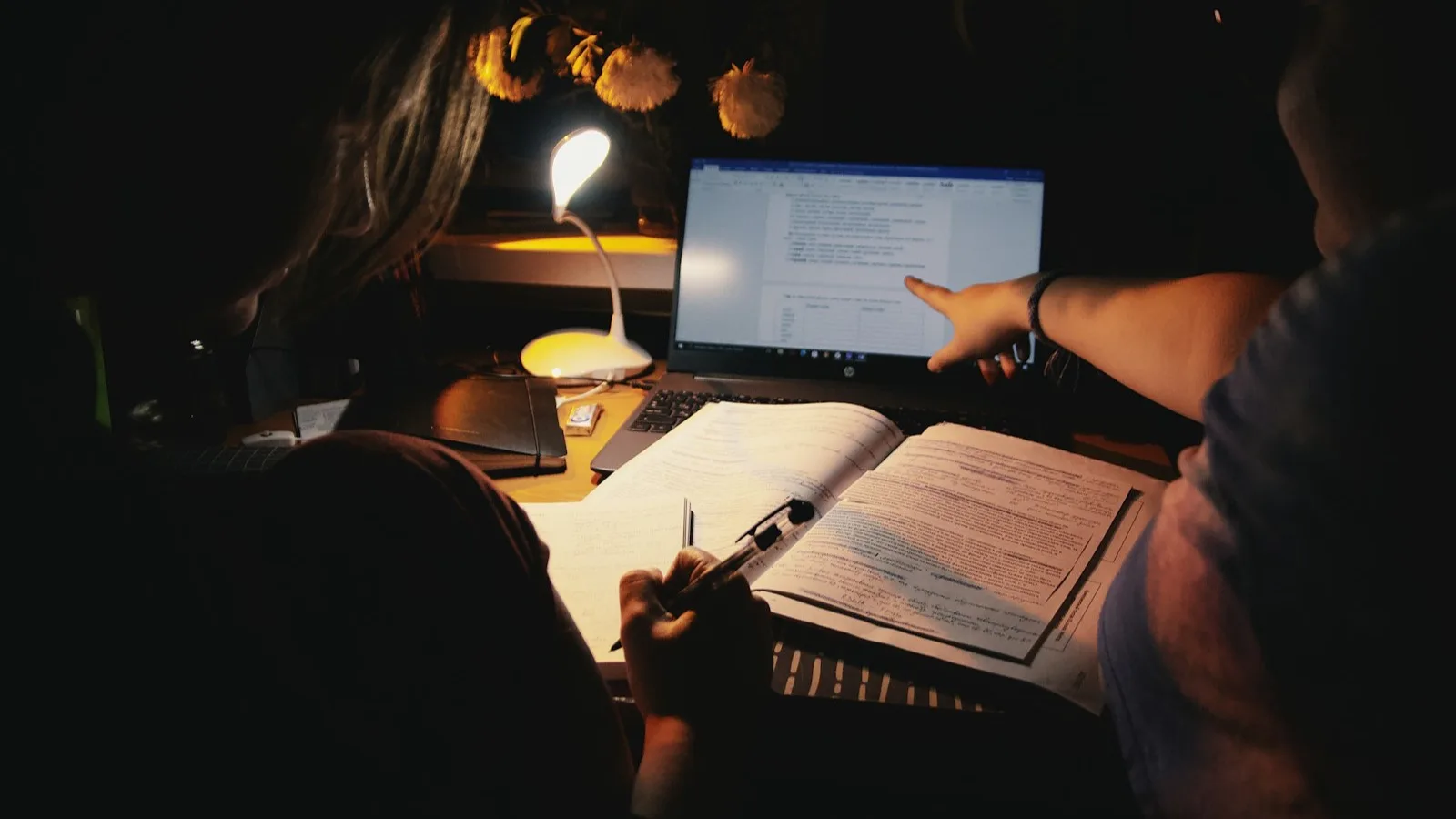Cuadernos de estudio y una lámpara sobre un escritorio