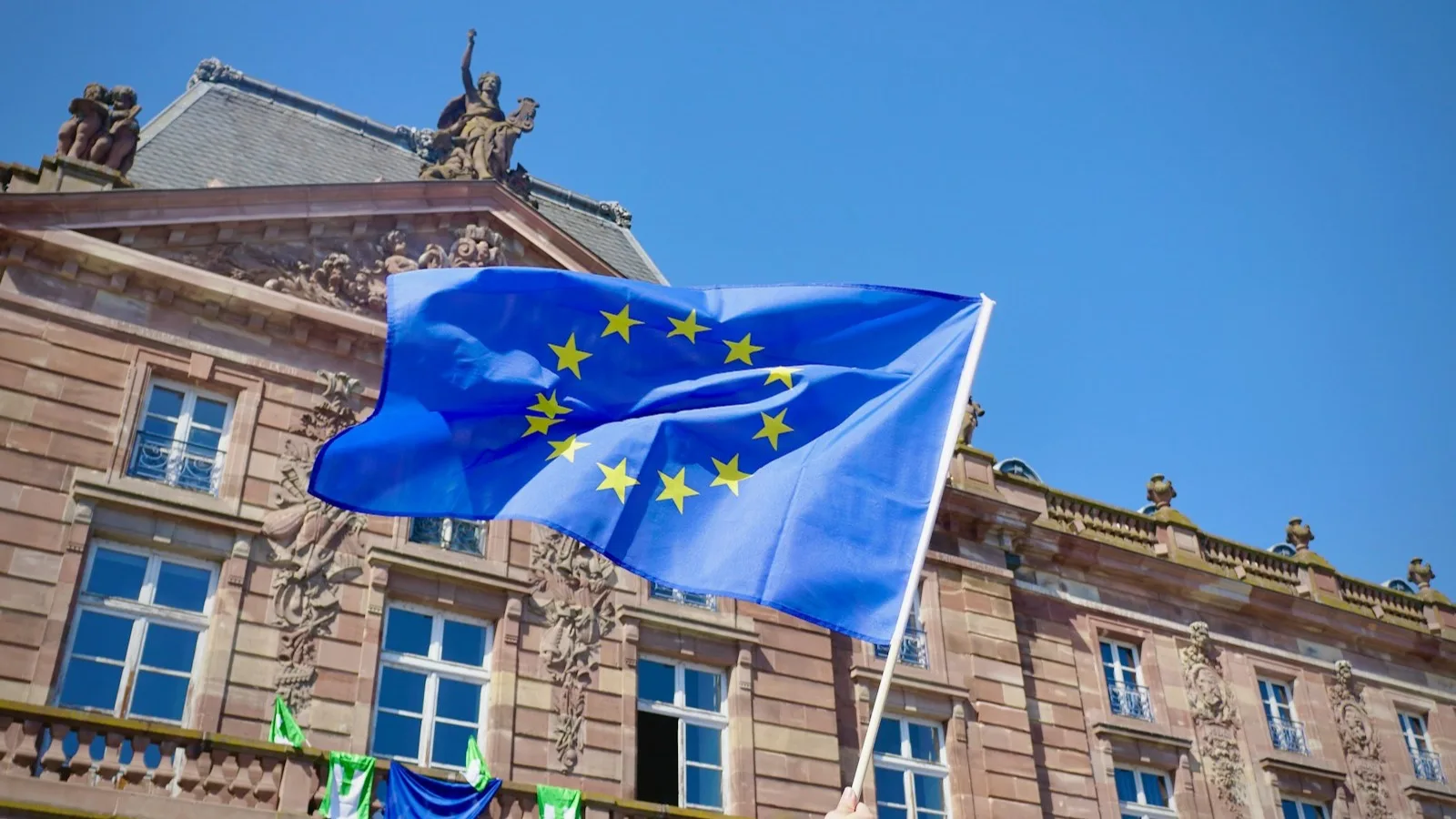 La bandera de la Unión Europea ondeando frente a un edificio institucional