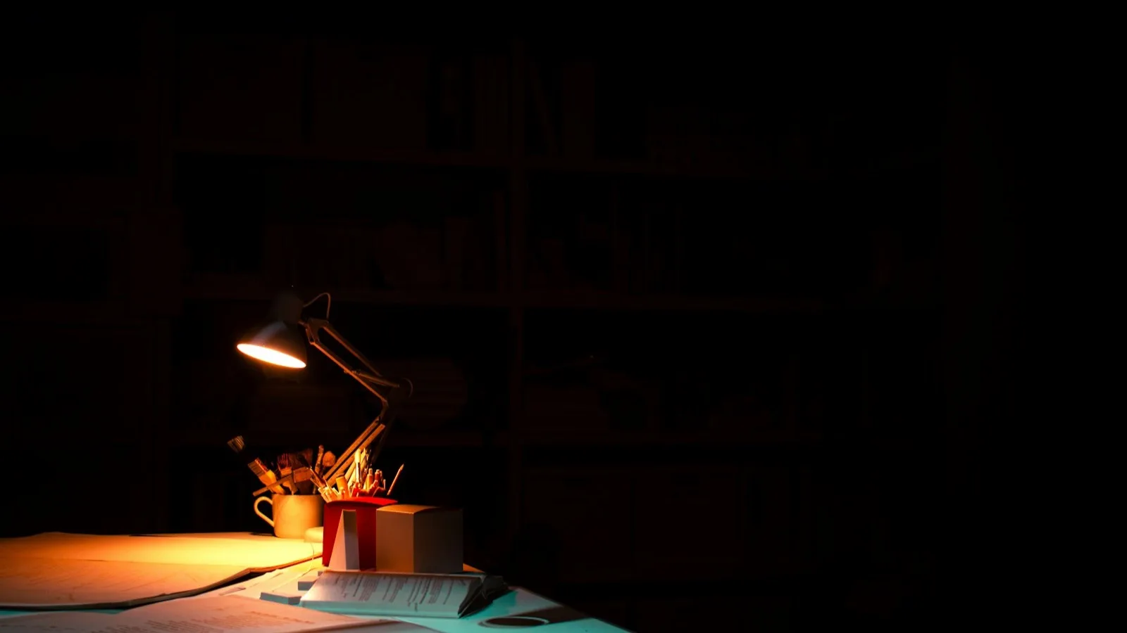 Una lupa sobre documentos en una mesa de trabajo en penumbra
