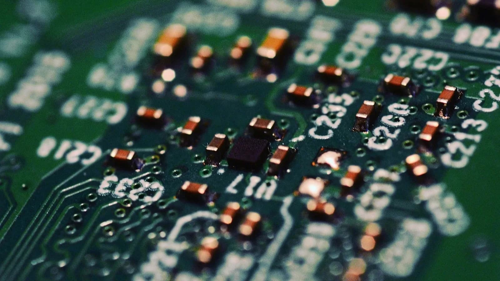 Primer plano macro de un circuito impreso verde con componentes electrónicos soldados