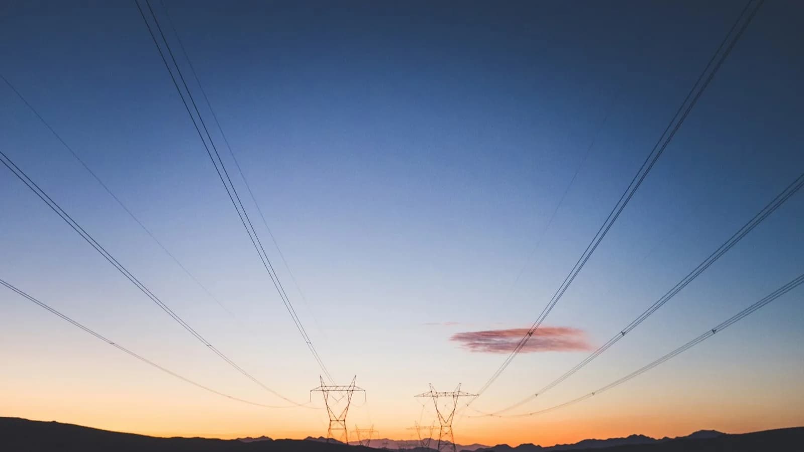 Torres de alta tensión y líneas eléctricas al anochecer